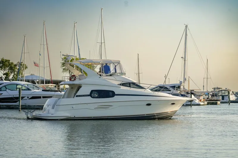 Slide: The Image of 2003 Silverton 410 Sport Bridge yacht docked in a marina with sailboats. - 43