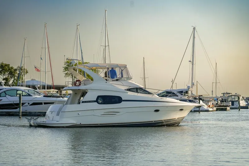 Slide: The Image of 2003 Silverton 410 Sport Bridge yacht docked in a marina with sailboats. - 44
