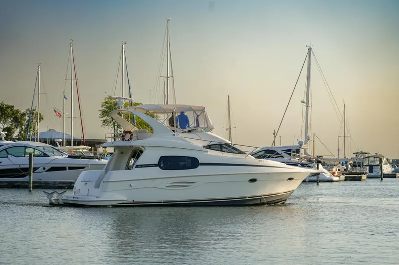 Slide: The Image of 2003 Silverton 410 Sport Bridge yacht docked in a marina with sailboats. - 45