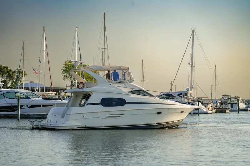 Slide: The Image of 2003 Silverton 410 Sport Bridge yacht docked in a marina with sailboats. - 46
