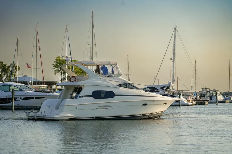 Slide: The Image of 2003 Silverton 410 Sport Bridge yacht docked in a marina at sunset. - 47