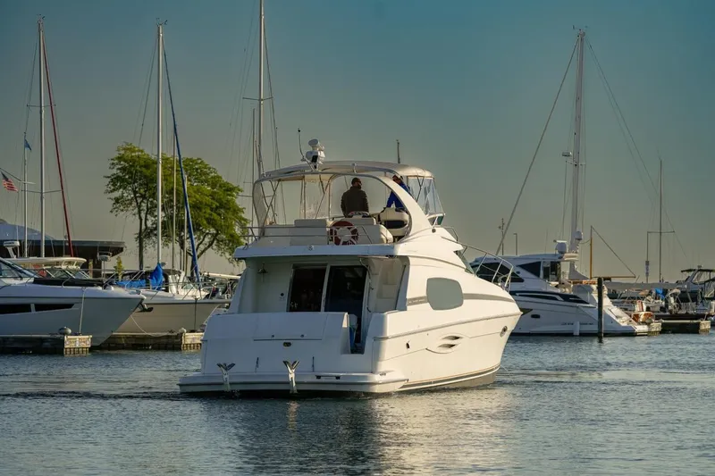 Slide: The Image of 2003 Silverton 410 Sport Bridge yacht docked in a marina with sailboats. - 50