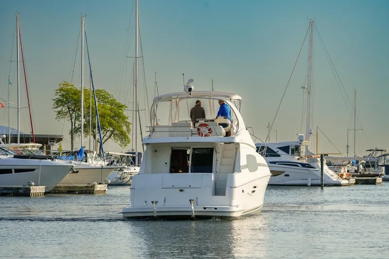 Slide: The Image of 2003 Silverton 410 Sport Bridge yacht in a marina, surrounded by sailboats. - 52