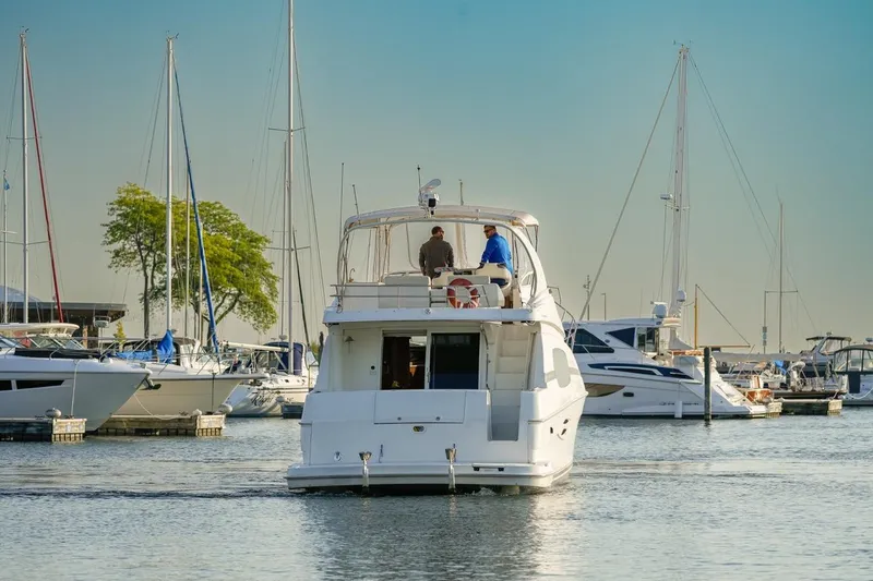 Slide: The Image of 2003 Silverton 410 Sport Bridge yacht in marina, surrounded by sailboats. - 53