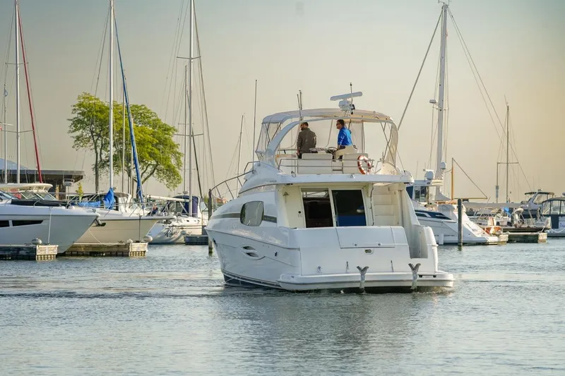 Slide: The Image of 2003 Silverton 410 Sport Bridge yacht in a marina, surrounded by sailboats. - 54
