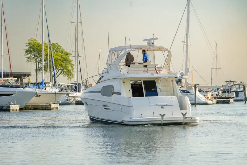 Slide: The Image of 2003 Silverton 410 Sport Bridge yacht in a marina, surrounded by sailboats. - 56