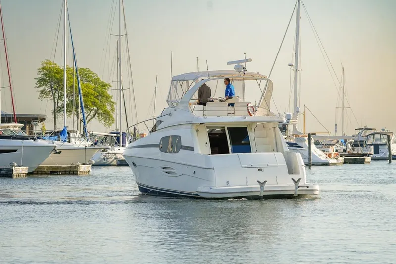 Slide: The Image of 2003 Silverton 410 Sport Bridge yacht in a marina, surrounded by sailboats. - 57