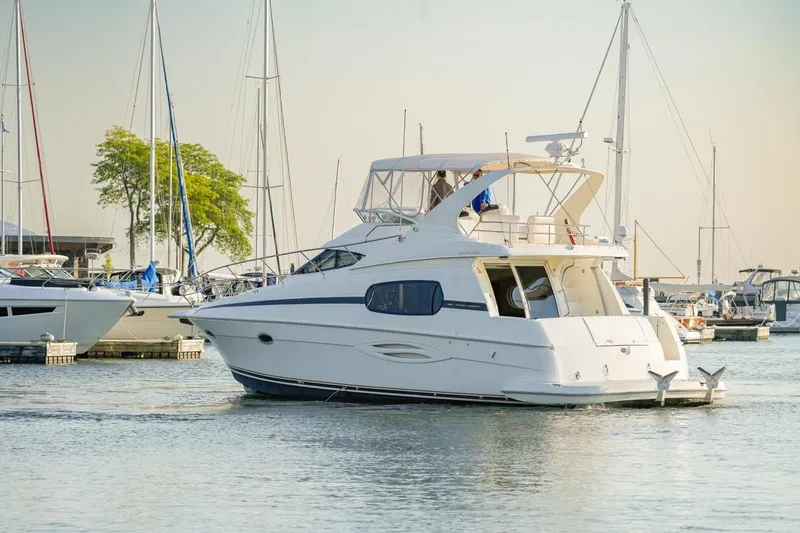 Slide: The Image of 2003 Silverton 410 Sport Bridge yacht docked in a marina with sailboats. - 58