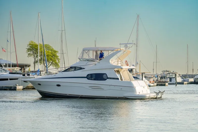 Slide: The Image of 2003 Silverton 410 Sport Bridge yacht docked in a marina with sailboats. - 60