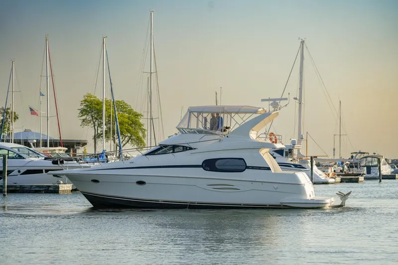 Slide: The Image of 2003 Silverton 410 Sport Bridge yacht docked in a marina with sailboats. - 62