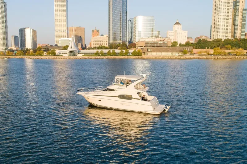 Slide: The Image of 2003 Silverton 410 Sport Bridge yacht on urban waterfront with city skyline. - 65