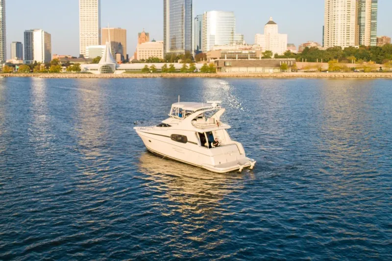Slide: The Image of 2003 Silverton 410 Sport Bridge yacht cruising near city skyline. - 66