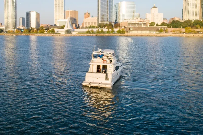 Slide: The Image of 2003 Silverton 410 Sport Bridge yacht cruising near city skyline. - 70