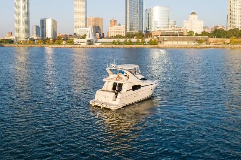 Slide: The Image of 2003 Silverton 410 Sport Bridge yacht cruising near city skyline. - 71