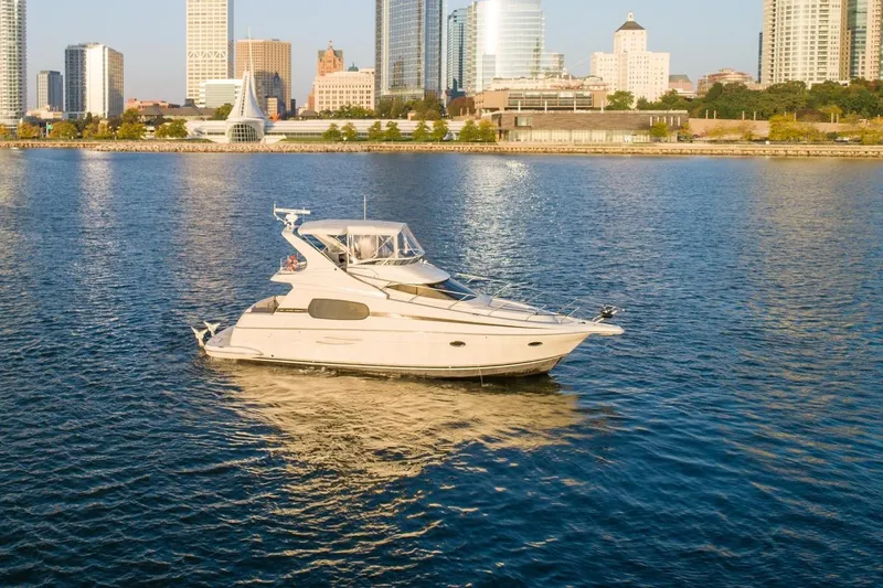 Slide: The Image of 2003 Silverton 410 Sport Bridge yacht cruising near city skyline. - 77