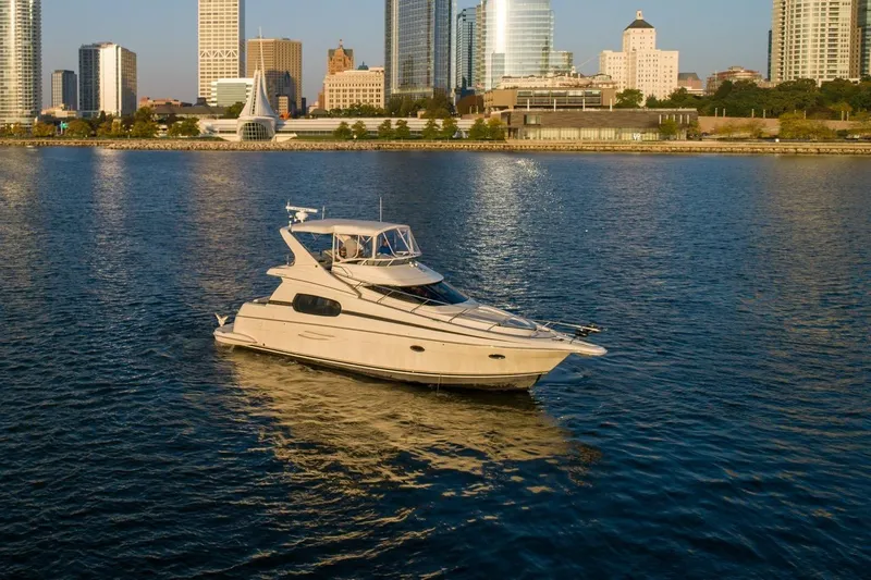 Slide: The Image of 2003 Silverton 410 Sport Bridge yacht on urban waterfront with city skyline. - 79