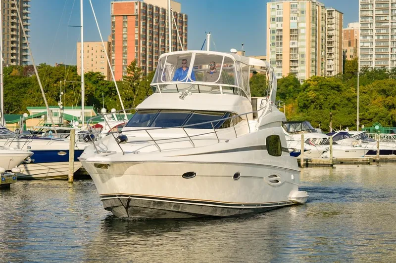 Slide: The Image of 2003 Silverton 410 Sport Bridge yacht docked in a marina with cityscape background. - 8