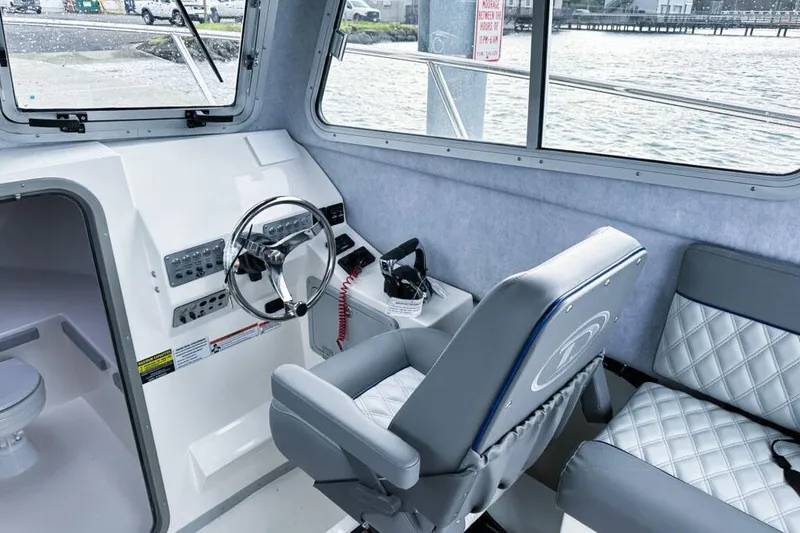 Slide: The Image of Manufacturer Provided Image: Interior of 2025 Defiance Admiral 260 EX boat with steering wheel and seating. - 4