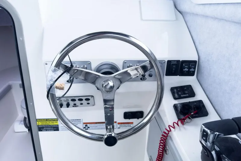 Slide: The Image of Manufacturer Provided Image: Steering wheel of 2025 Defiance Admiral 260 EX boat with control panel. - 5