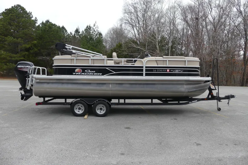 Slide: The Image of 2018 Sun Tracker Party Barge 22 DLX pontoon boat on trailer in parking lot. - 2
