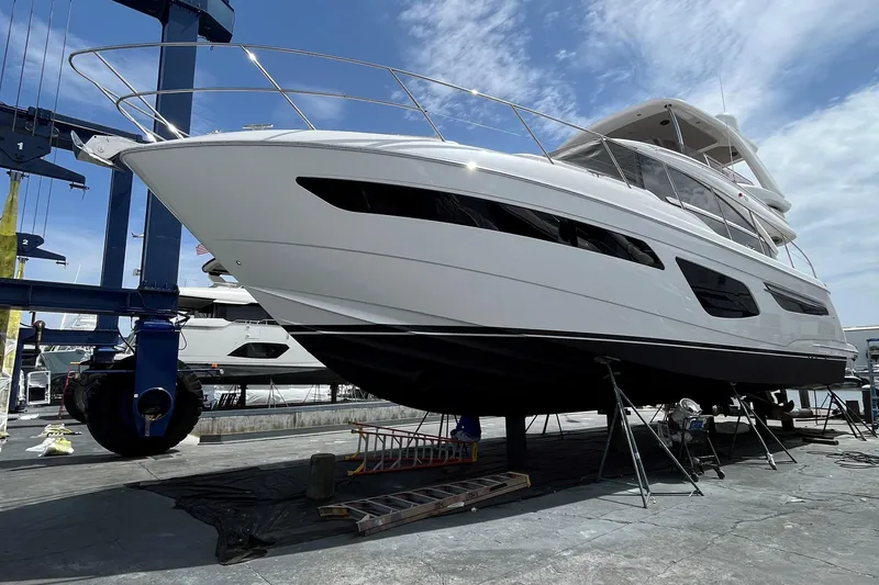 Slide: The Image of 2022 Princess 55 Flybridge yacht on dry dock under a clear sky. - 105