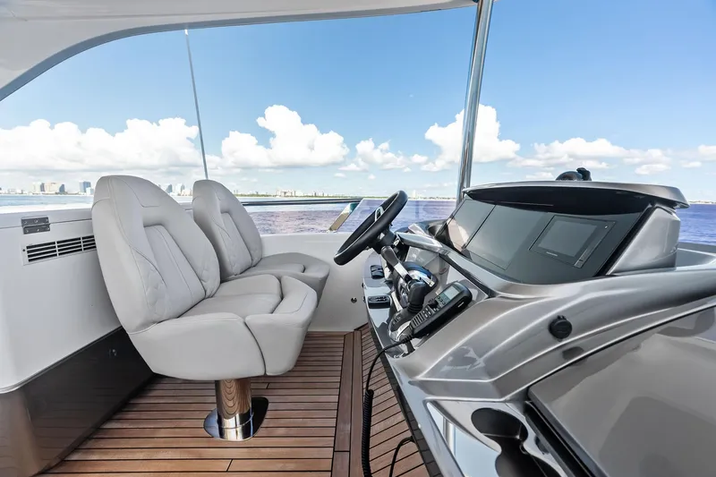 Slide: The Image of Flybridge helm of 2022 Princess 55 yacht with luxurious seating and modern controls. - 13