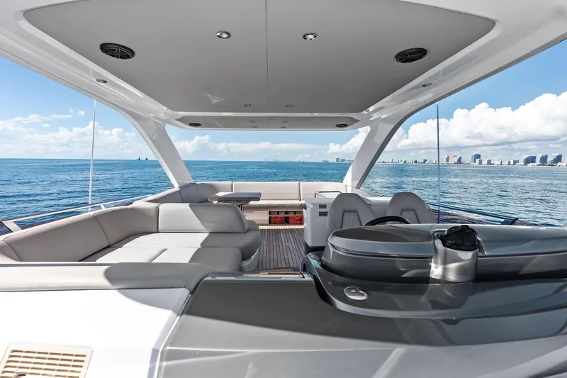 Slide: The Image of Luxurious 2022 Princess 55 flybridge yacht with spacious seating, overlooking serene ocean and cityscape. - 16