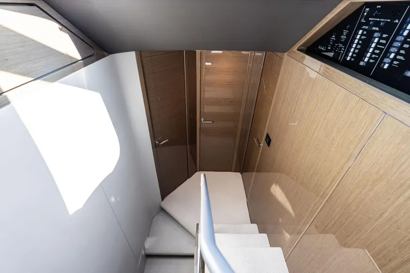 Slide: The Image of Interior staircase of 2022 Princess 55 Flybridge yacht, featuring modern wood paneling. - 23