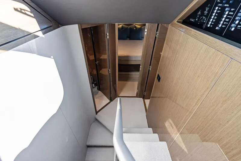 Slide: The Image of Interior view of 2022 Princess 55 Flybridge yacht, featuring stairs and a cozy bedroom. - 24