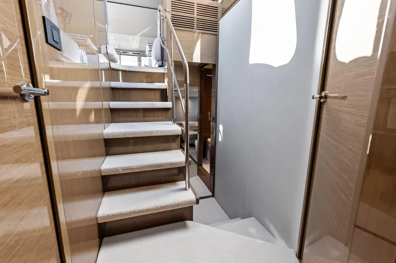 Slide: The Image of Luxurious interior staircase of 2022 Princess 55 Flybridge yacht, featuring elegant wood and carpet design. - 28