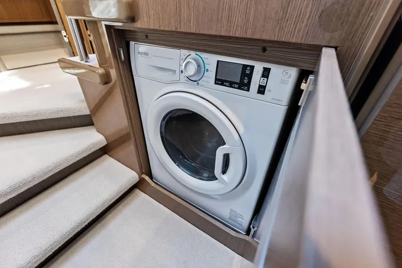 Slide: The Image of Built-in washing machine on 2022 Princess 55 Flybridge yacht, near carpeted stairs. - 42