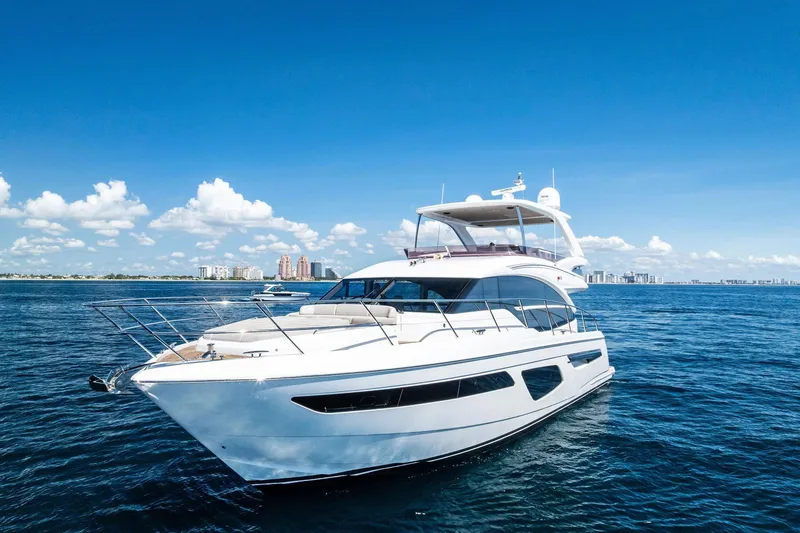 Slide: The Image of Luxury 2022 Princess 55 Flybridge yacht cruising on open water under clear blue skies. - 50