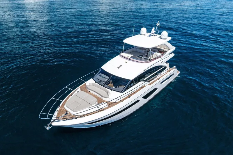 Slide: The Image of Luxury 2022 Princess 55 Flybridge yacht cruising on open blue sea. - 55