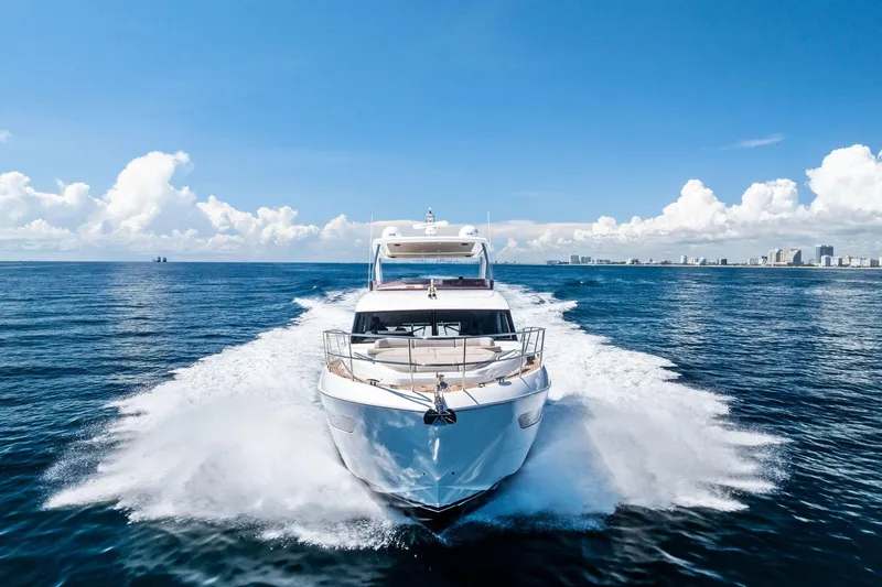 Slide: The Image of 2022 Princess 55 Flybridge yacht cruising on open sea under clear blue sky. - 58