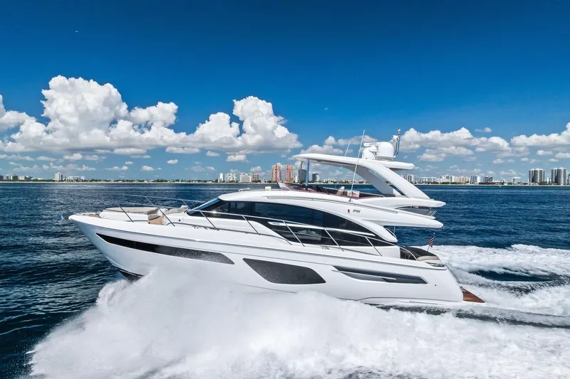 Slide: The Image of 2022 Princess 55 Flybridge yacht cruising on open water under a clear blue sky. - 60