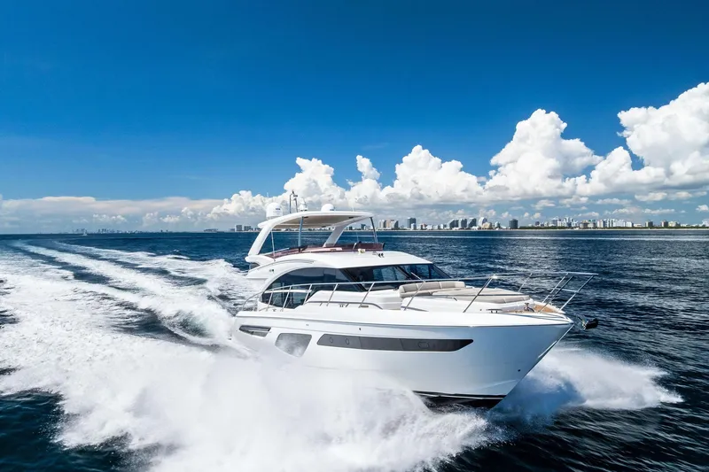 Slide: The Image of 2022 Princess 55 Flybridge yacht cruising on open water under a clear blue sky. - 64