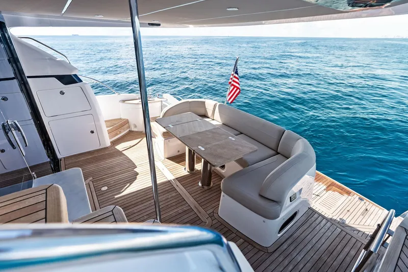 Slide: The Image of Luxurious 2022 Princess 55 Flybridge yacht with elegant seating, ocean view, and American flag. - 83