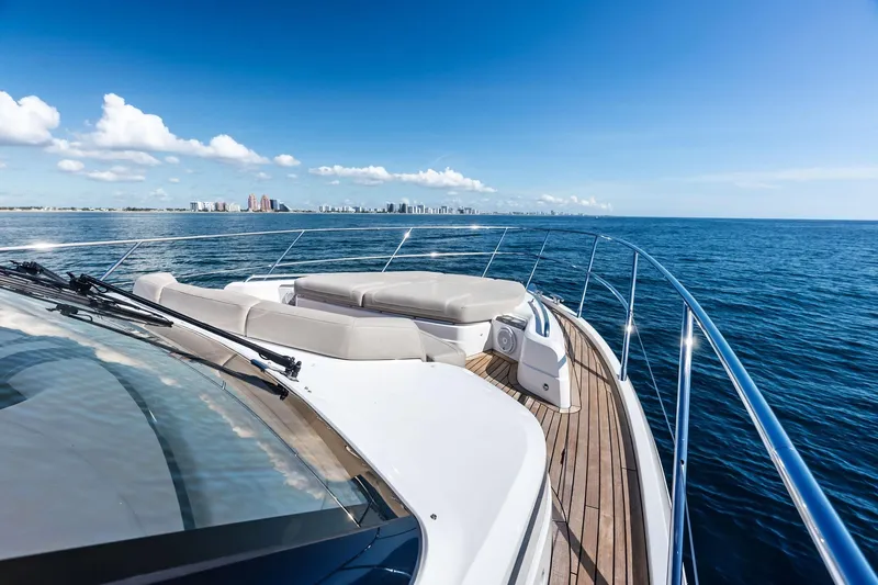 Slide: The Image of Luxurious 2022 Princess 55 flybridge yacht cruising on open sea with city skyline view. - 85