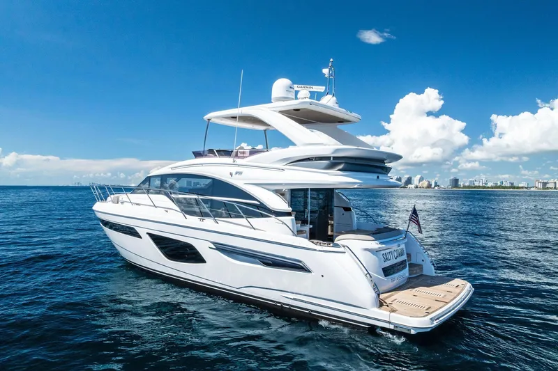 Slide: The Image of Luxury 2022 Princess 55 Flybridge yacht cruising on open sea under clear blue sky. - 97