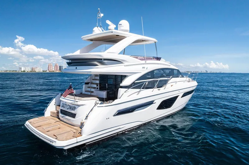 Slide: The Image of Luxury 2022 Princess 55 Flybridge yacht cruising on open sea under clear blue sky. - 98