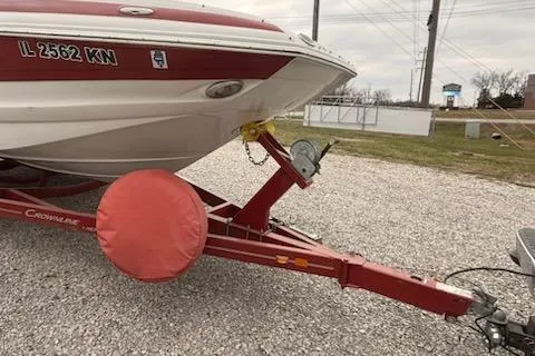 Slide: The Image of 2012 Crownline Eclipse E2 boat on red trailer, parked on gravel. - 11