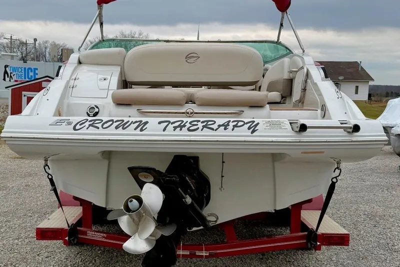 Slide: The Image of 2012 Crownline Eclipse E2 boat named "Crown Therapy" on a trailer, rear view. - 2