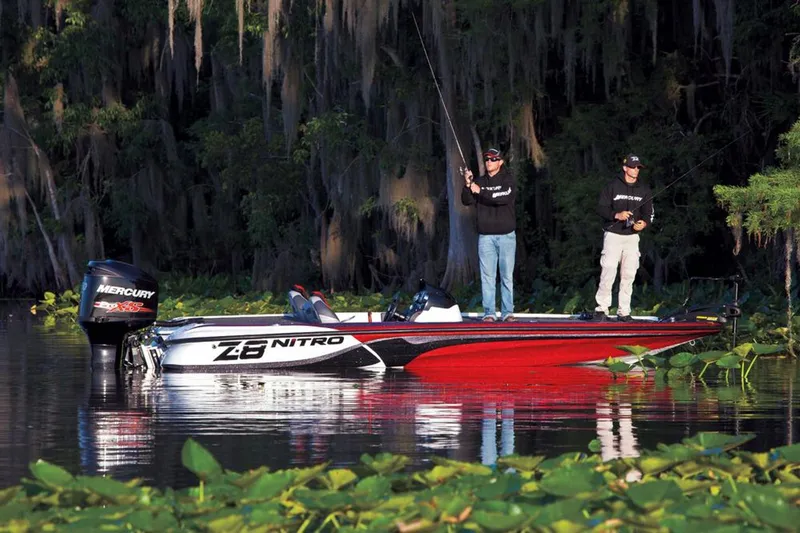 Slide: The Image of Manufacturer Provided Image: Two people fishing on a 2013 Nitro Z-8 boat in a lush, serene lake. - 8