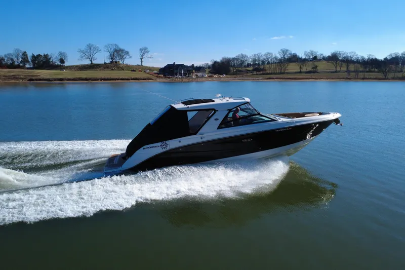 Slide: The Image of 2022 Sea Ray SLX 400 cruising on a serene lake under a clear blue sky. - 10