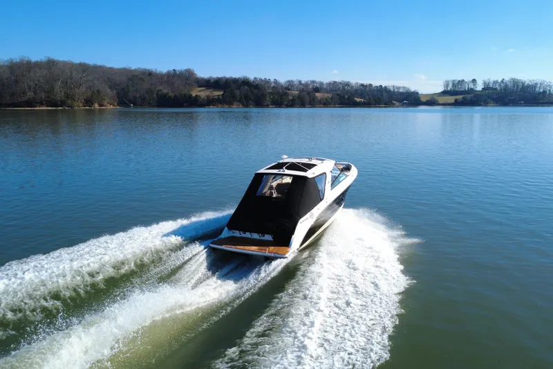 Slide: The Image of 2022 Sea Ray SLX 400 cruising on a serene lake under a clear blue sky. - 11