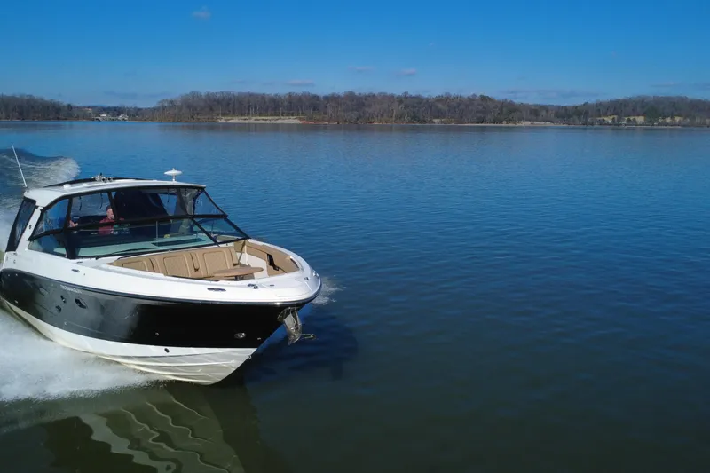 Slide: The Image of 2022 Sea Ray SLX 400 cruising on a calm lake under a clear blue sky. - 12