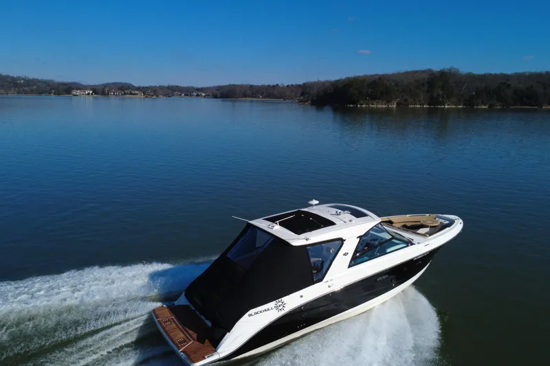 Slide: The Image of 2022 Sea Ray SLX 400 cruising on a serene lake under a clear blue sky. - 16