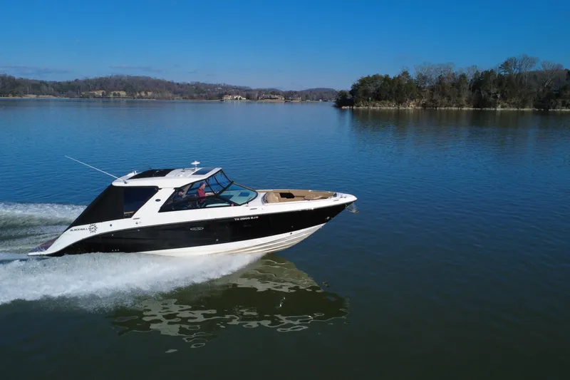 Slide: The Image of 2022 Sea Ray SLX 400 cruising on a serene lake under a clear blue sky. - 17
