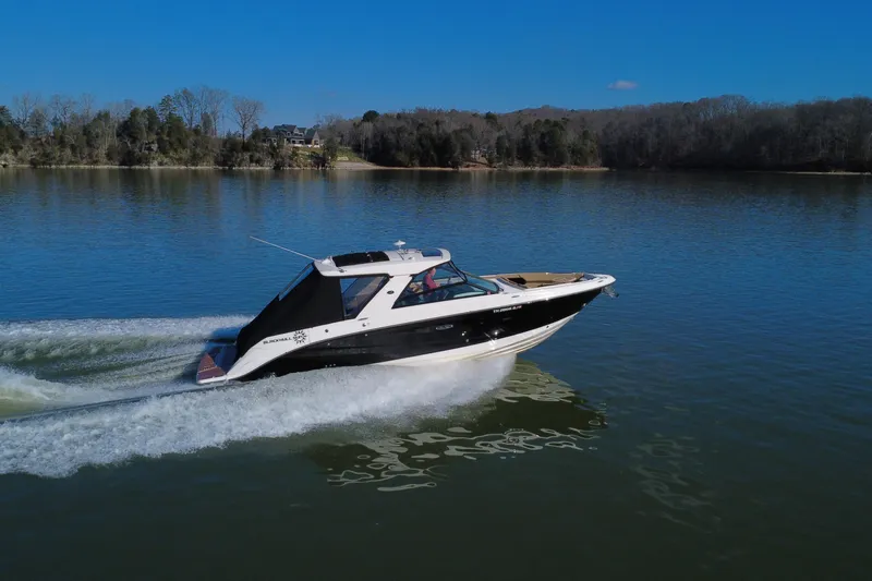 Slide: The Image of 2022 Sea Ray SLX 400 cruising on a serene lake under a clear blue sky. - 2