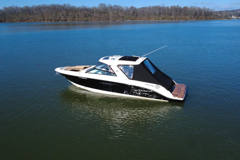 Slide: The Image of 2022 Sea Ray SLX 400 boat on calm lake with wooded shoreline. - 27